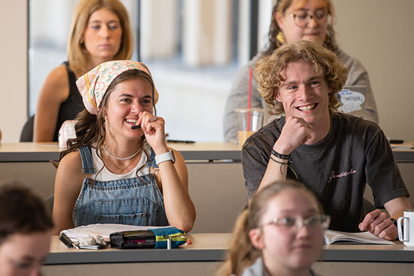 college students listening at a desk