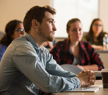 college student listening at a desk