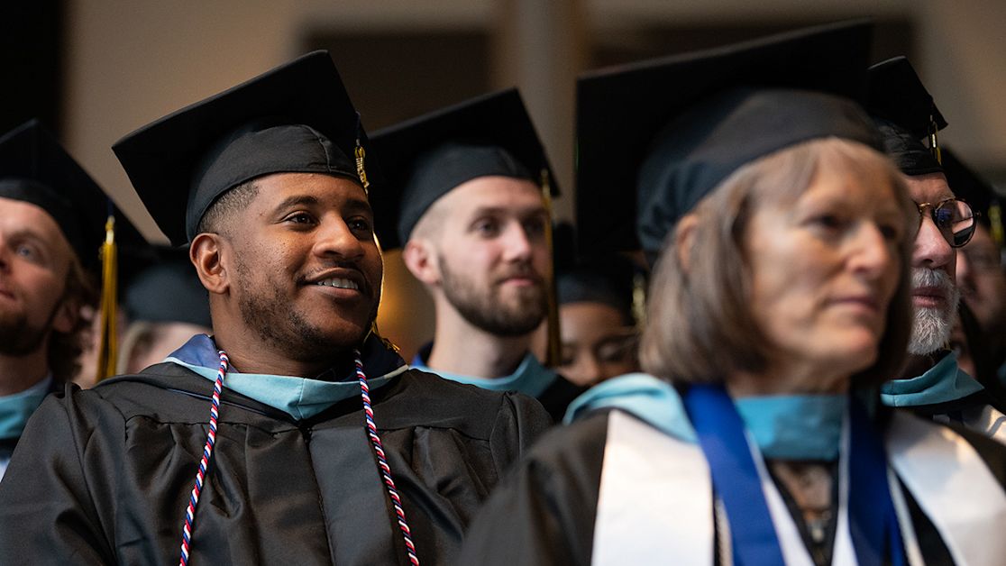 Adult students in graduation wear during ceremony