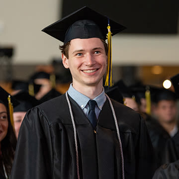 Male CUS student at commencement with cap and gown