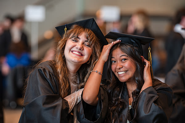 two smiling graduates at ccu commencement