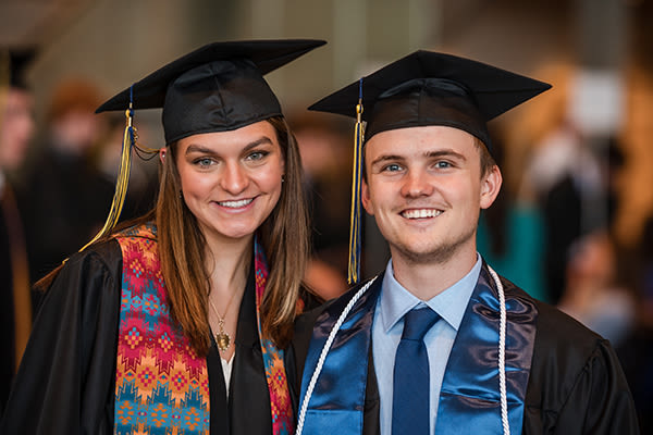 two smiling graduates at ccu commencement