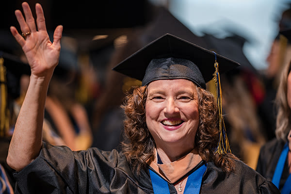 waving woman graduate