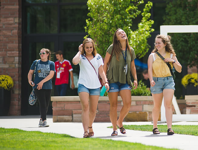 Couple of students walking across campus in the summer