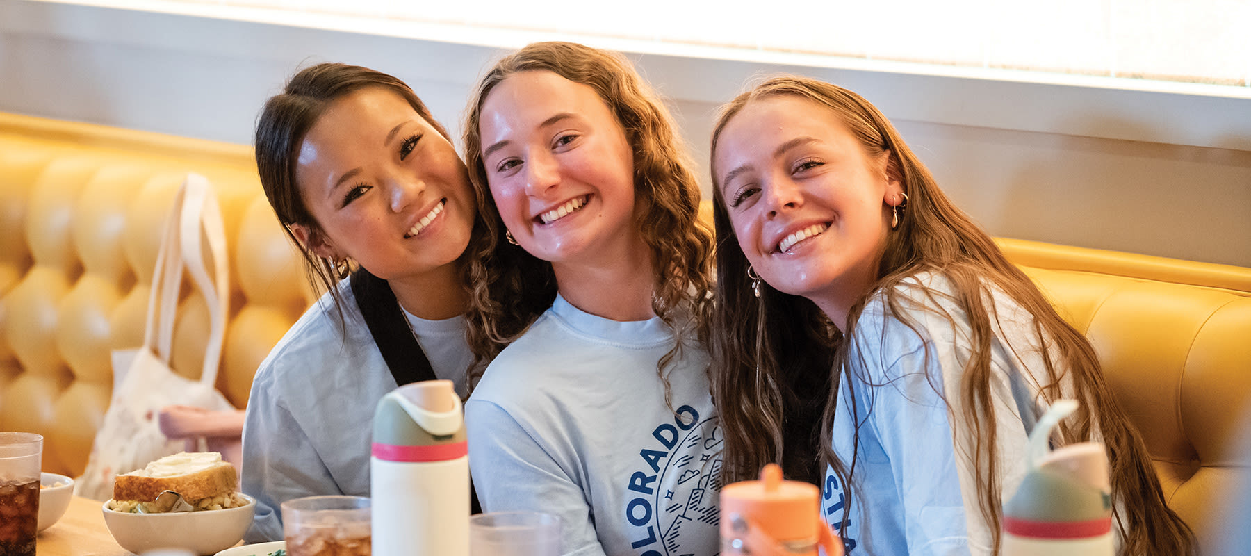 3 female students smiling at the camera