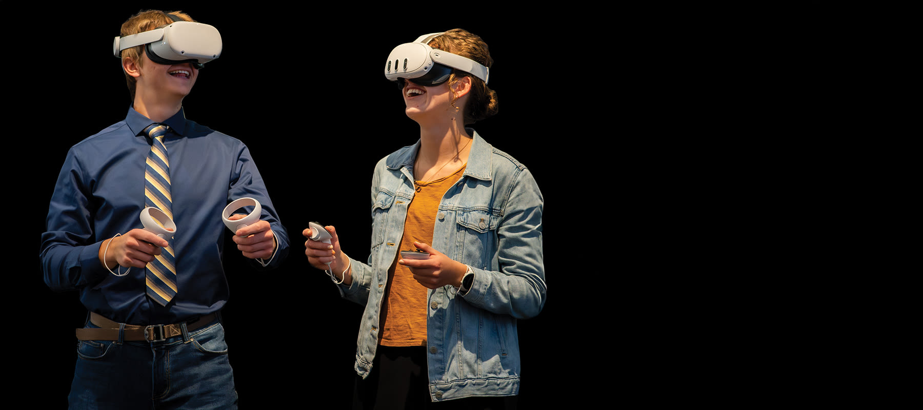 Two students smile and use a VR headset