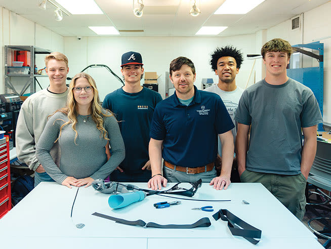 engineering faculty and students with bionic arm thumbnail