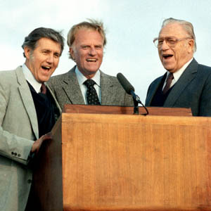 Billy Graham and his team behind a podium