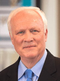 harold s wearing a suit and smiling