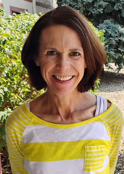 Emily Harris tiffany cox smiling outside wearing a yellow top