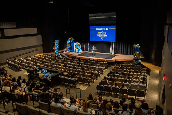 president hogue on a stage speaking to students at discovery days