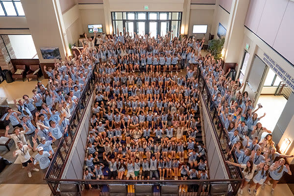 large group of students waving on stairs