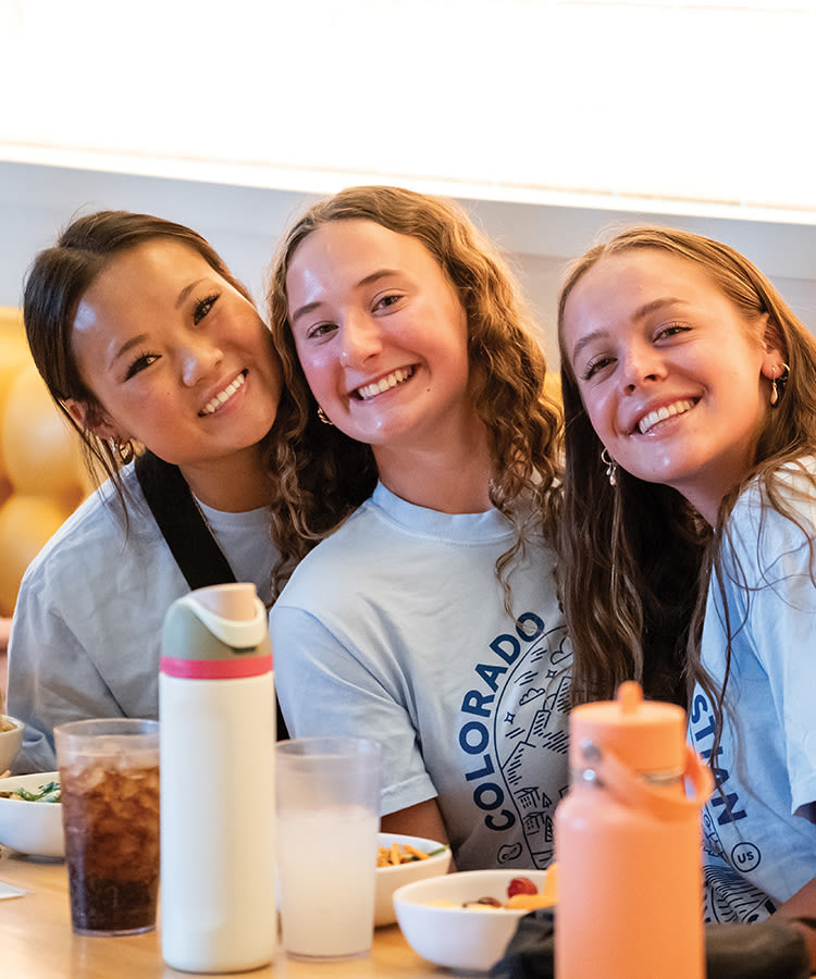 3 female students smiling at the camera