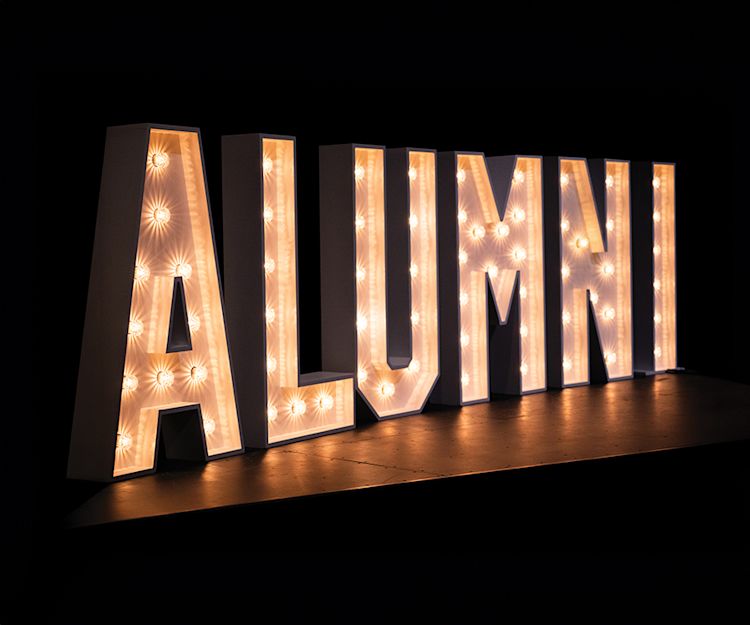 long rectangular image of glowing letters that spell out alumni