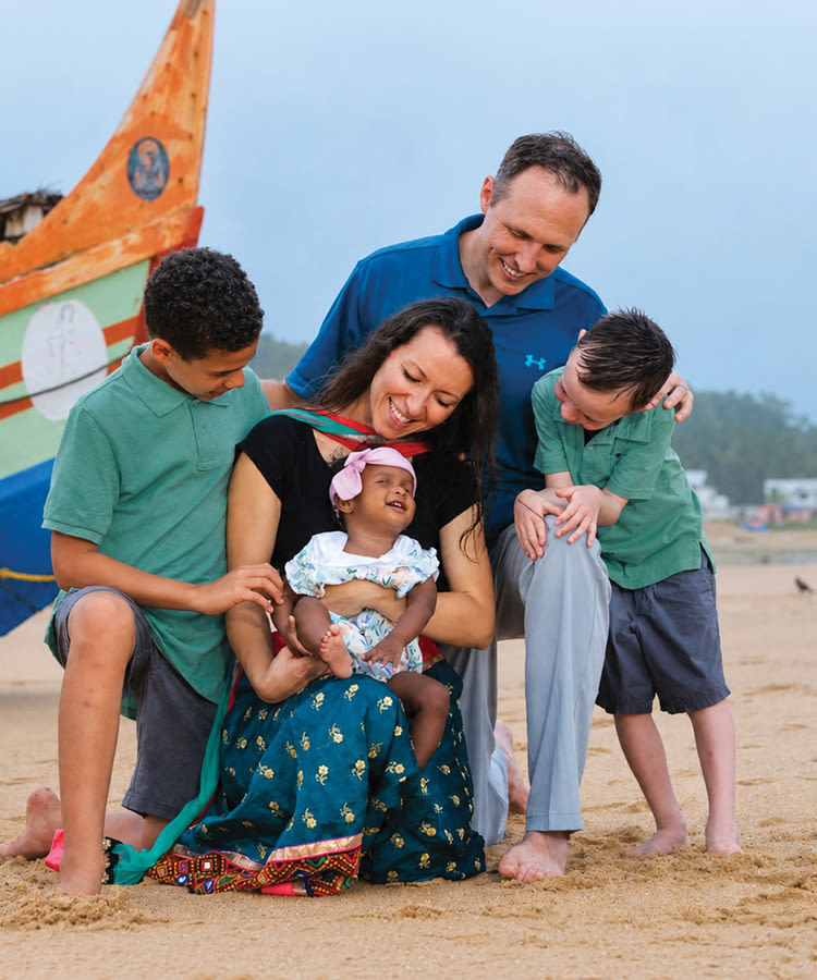 The Ryder family poses together for a photo on a beach
