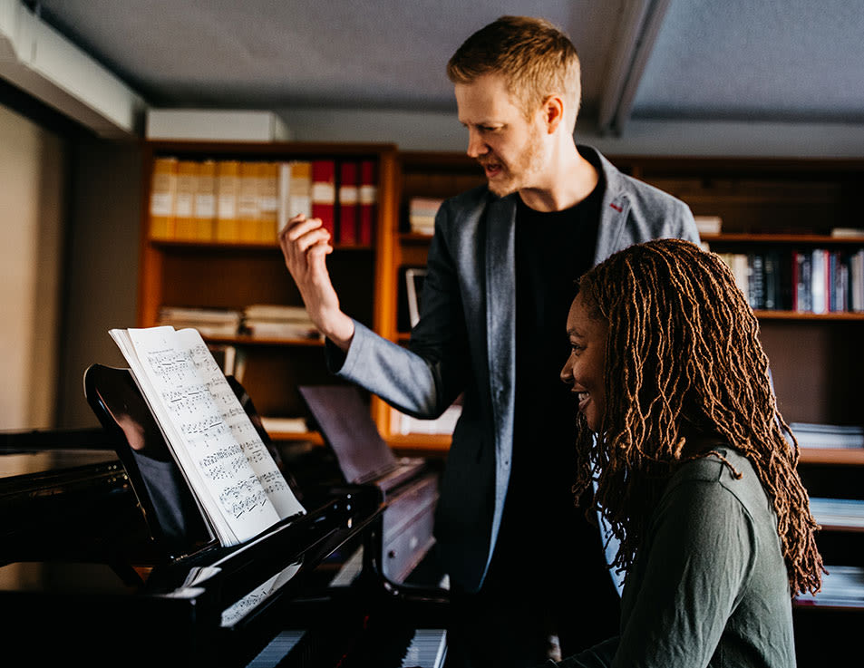 ccu school of music faculty sitting in a practice room at a piano with a student