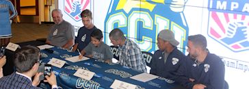 A boy is signing a soccer contract