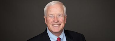 Dr. Sweeting wearing suit and smiling