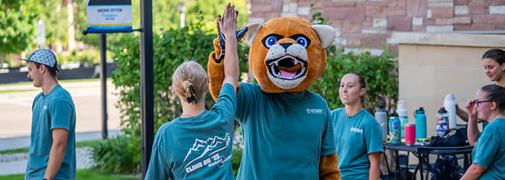 students high fiving cougar mascot during wow