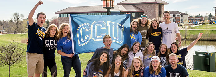 Group of happy students holding CCU banner and wearing CCU T-shirts