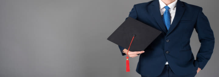 man in suite holding a graduation cap
