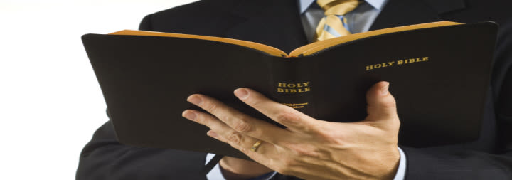 man in suit holding a bible