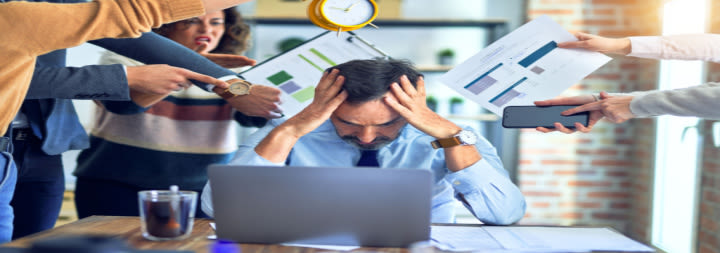 male holding head at desk