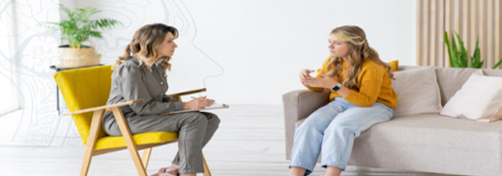 Women and young girl sitting down on chairs talking
