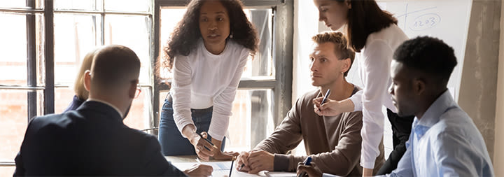 Six businesspeople congregated around a table.
