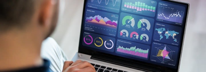 man on a laptop with metrics on the screen