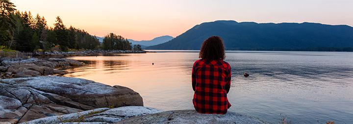 woman sitting by a peaceful lake