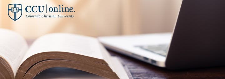 open bible next to laptop