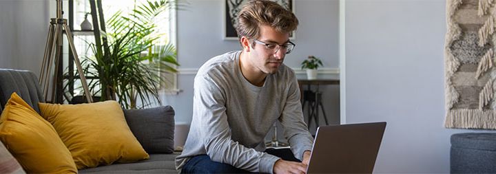 Man sitting in living room working on his laptop