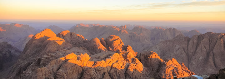 A mountain peak is illuminated with golden light.
