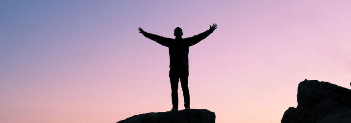 A silhouette of a man with dusk in the background