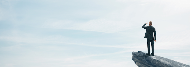 business man standing on top of a mountain
