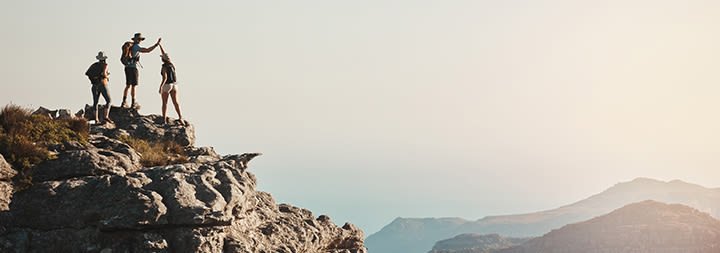 People high-fiving on mountain summit