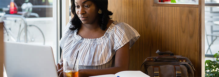 female ccu online student working on a laptop