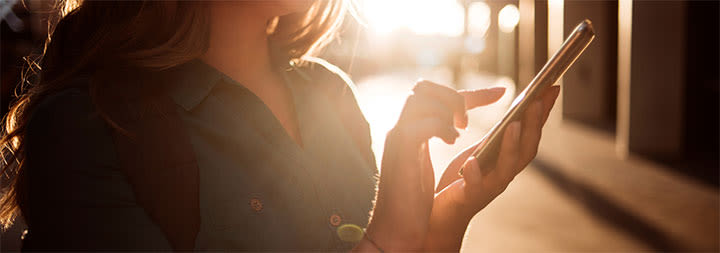 woman standing scrolling on her phone