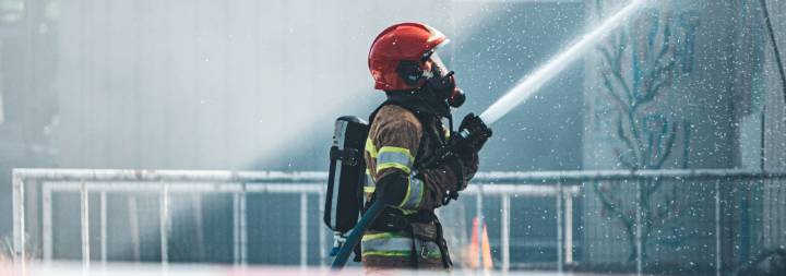 firefighter spraying water with a hose