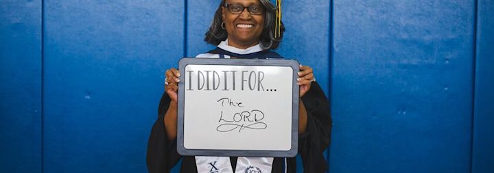 A 2017 CCU graduate is posing for a photo at CCU's Commencement.
