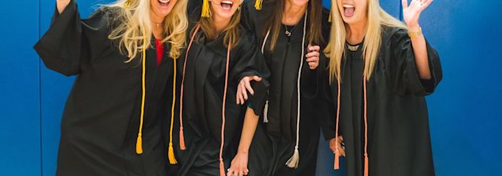 Adult students are posing for a photo at their CCU graduation ceremony.