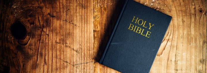 Picture of Holy Bible on a wooden table.