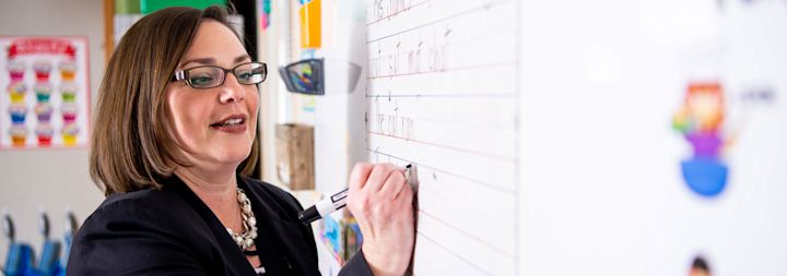 a teacher at her whiteboard