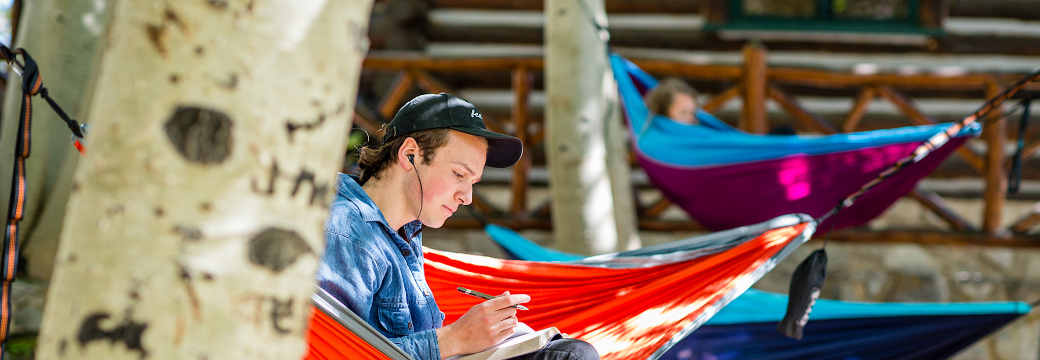 CCU student doing homework in a hammock on a nice, sunny day.