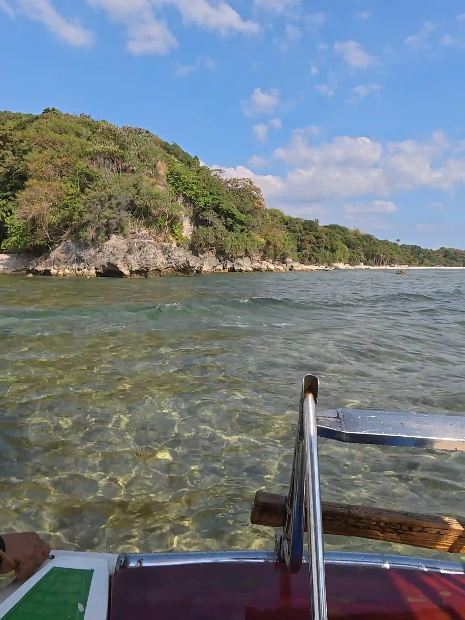 View from inside a bangka looking out over the open sea toward Talim Beach with blue water and scattered clouds above Matabungkay Lian Batangas
