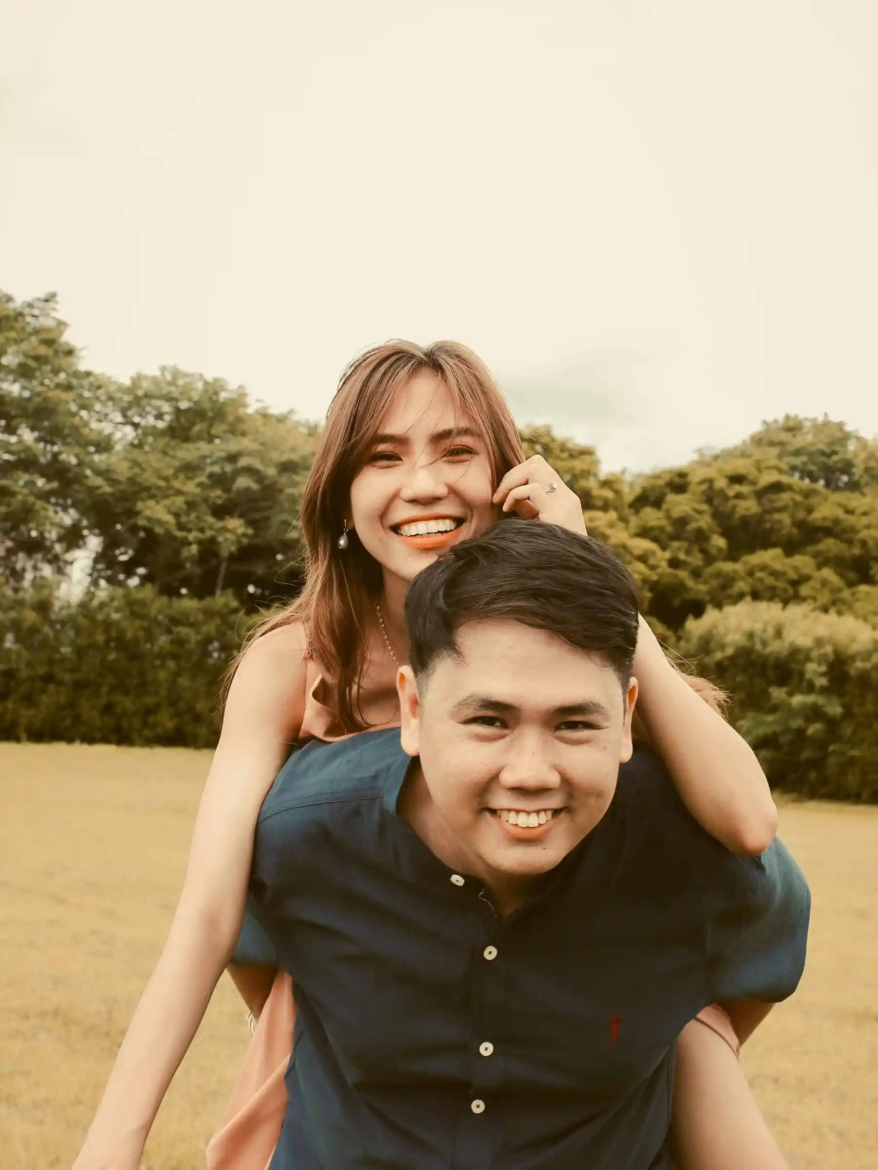 Ryan Lester Celorico carrying Judy Ann on his back in an open field at Southwoods Alabang during their prenuptial shoot
