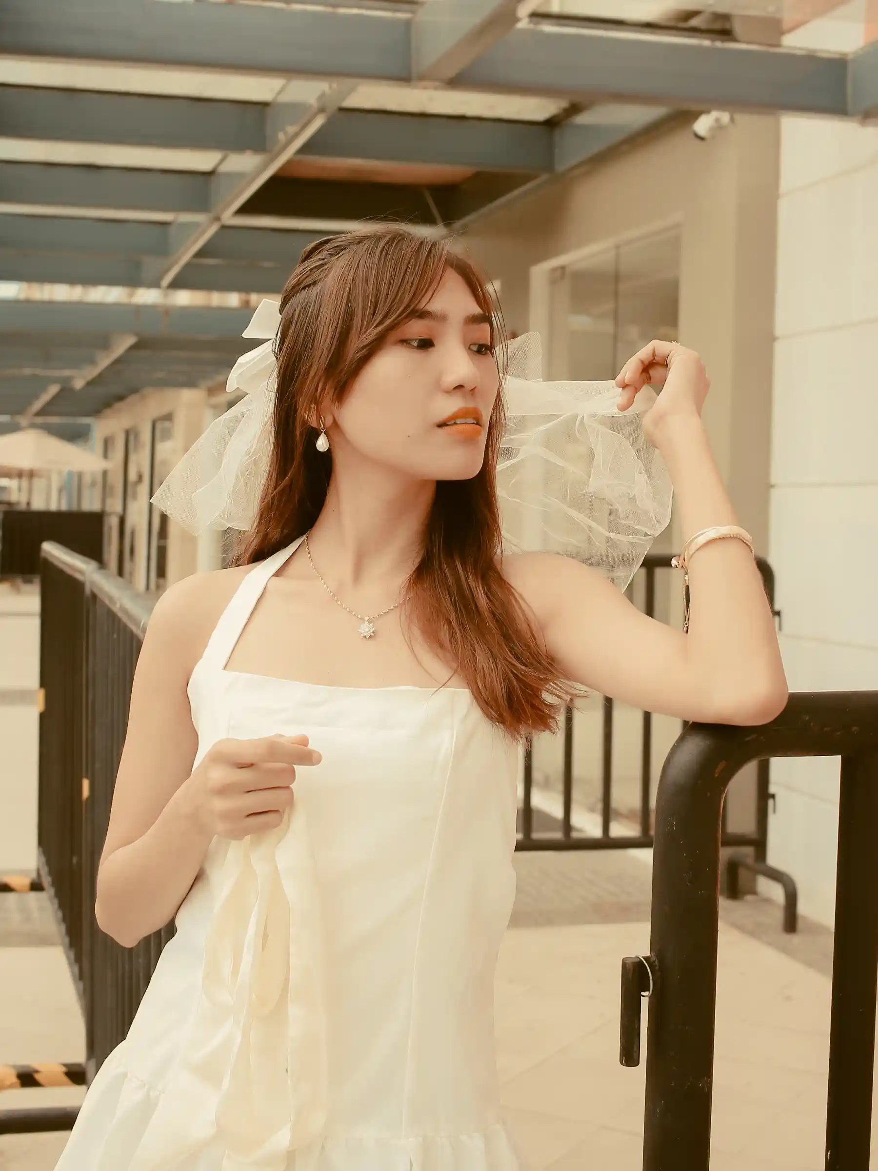 Judy Ann Celorico in a white dress and tulle veil standing at a rooftop railing at Southwoods Alabang