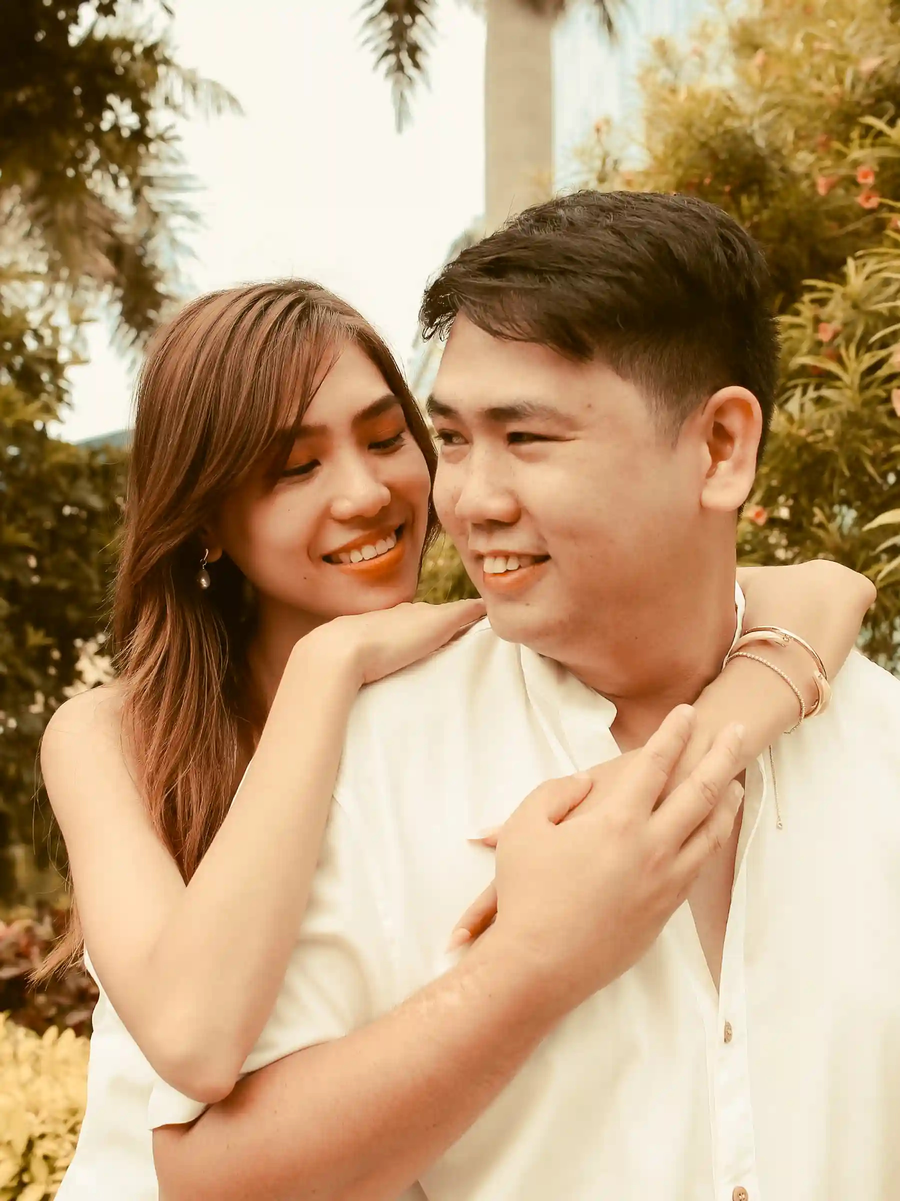 Judy Ann Celorico embracing Ryan Lester Celorico from behind in a garden with tropical plants at Southwoods Alabang