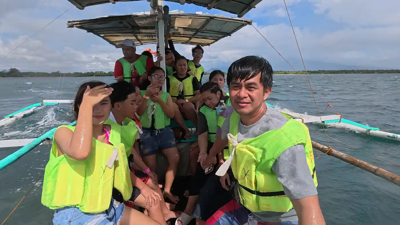 Family group in bright green life vests seated on a bangka outrigger boat on open water at Villa Del Prado in Sariaya Quezon